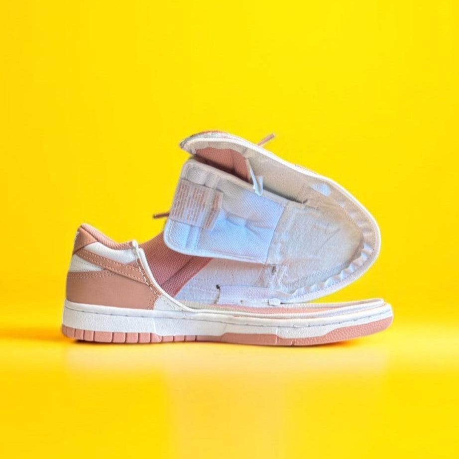 A pink and white Nike dunk low with a wrap around zipper on a yellow background