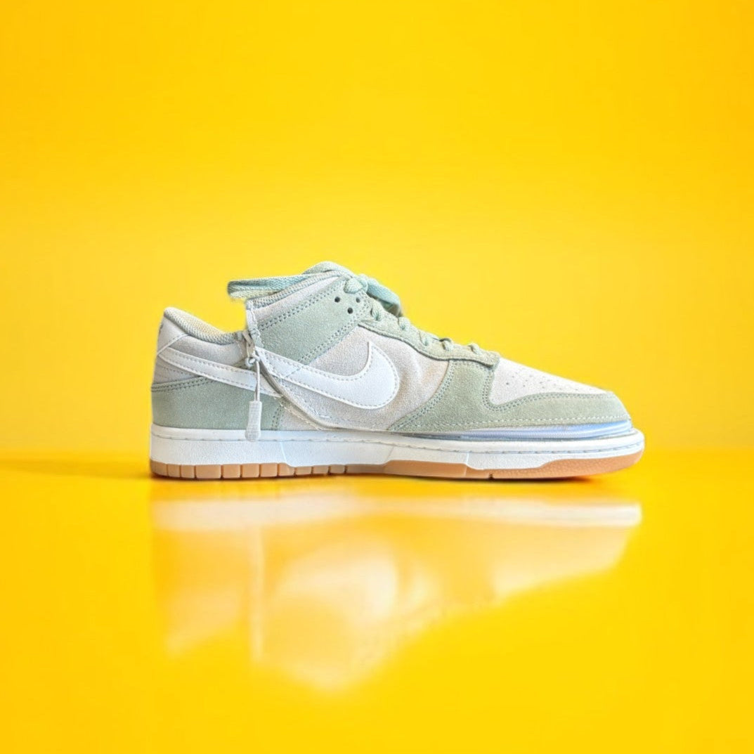 Green and white Nike dunk low with a zipper on a yellow background