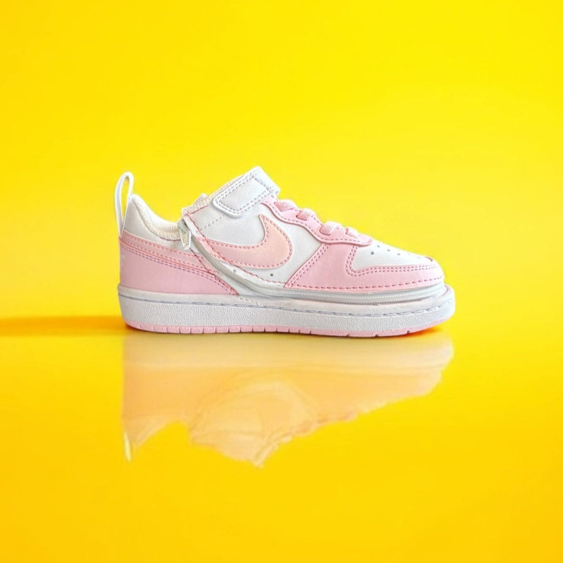 White and pink nike shoe with a zipper on a yellow background