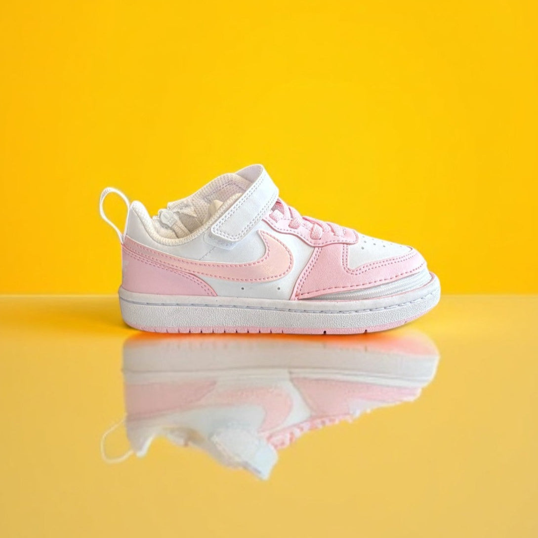 White and pink nike shoe with a zipper on a yellow background