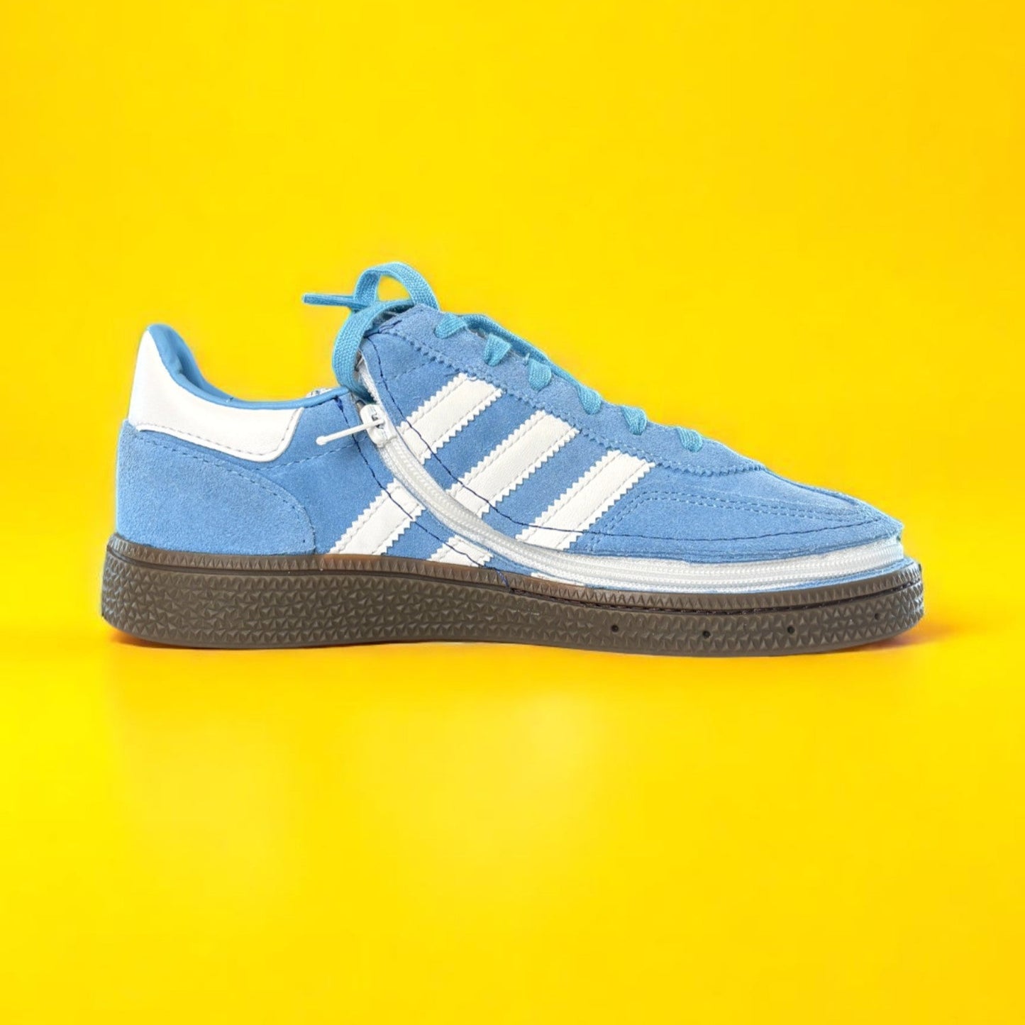 Blue Adidas sneaker with white stripes on a yellow background