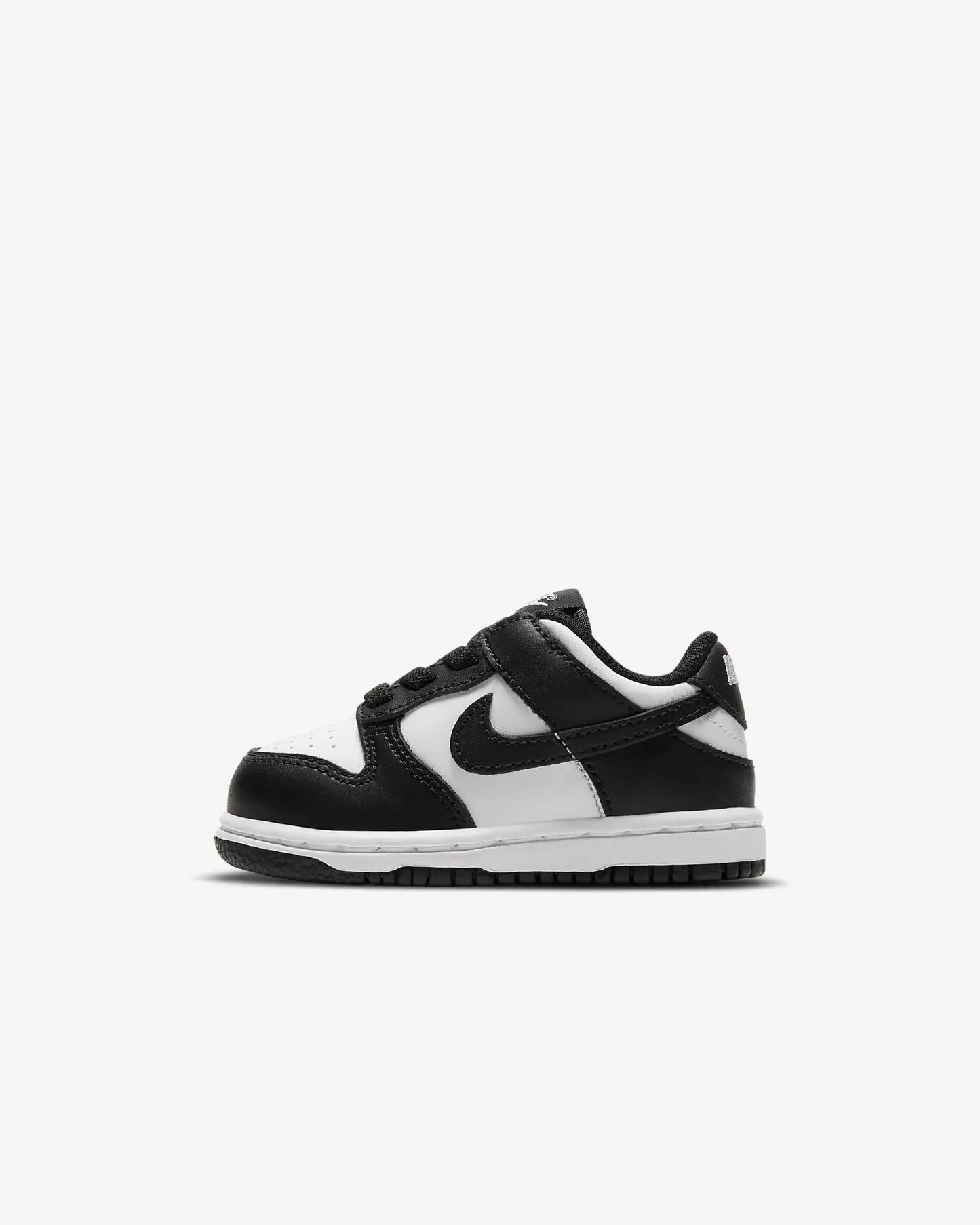 A toddler-sized Nike Dunk Low sneaker in white and black.