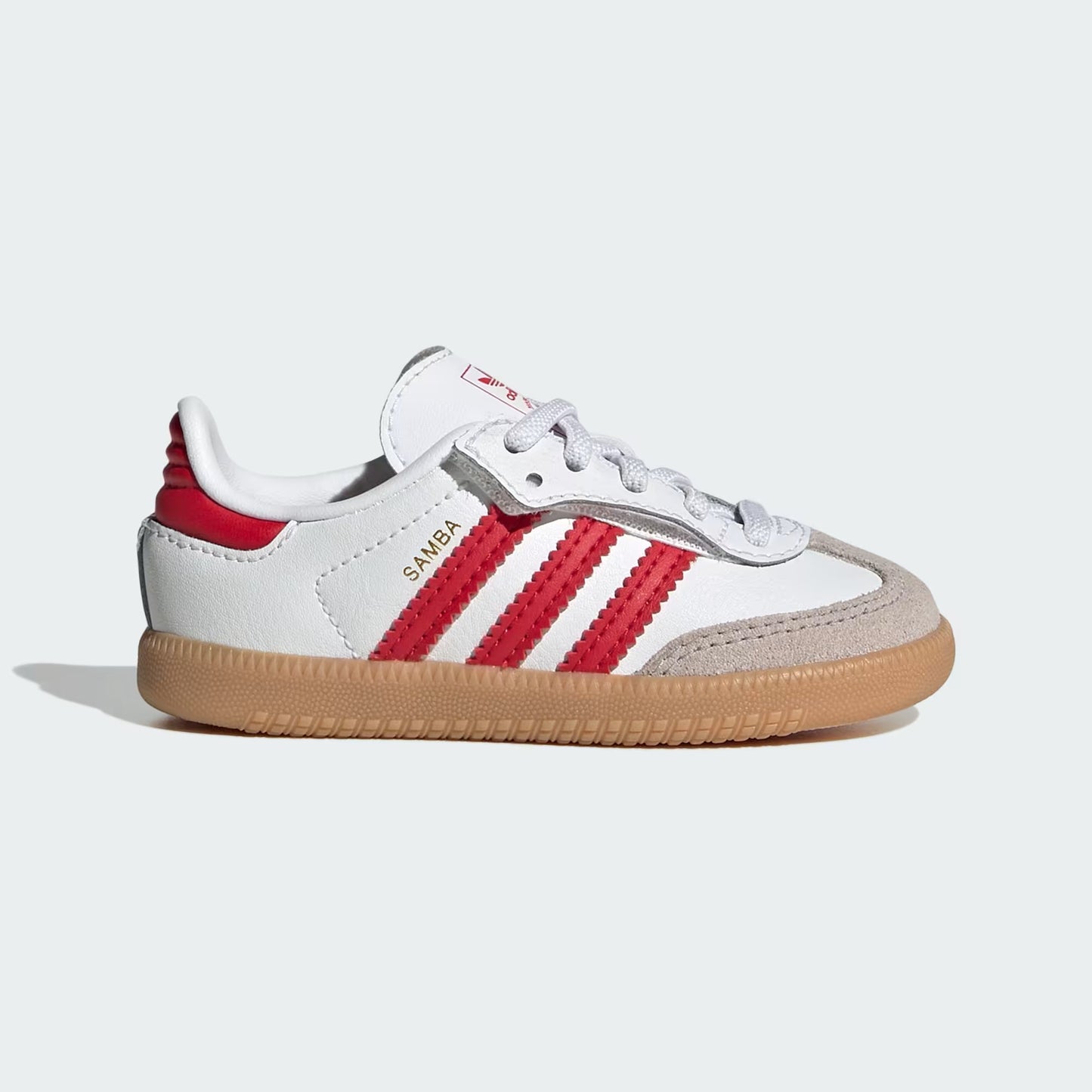 White and red Adidas sneaker with brown sole on a light gray background