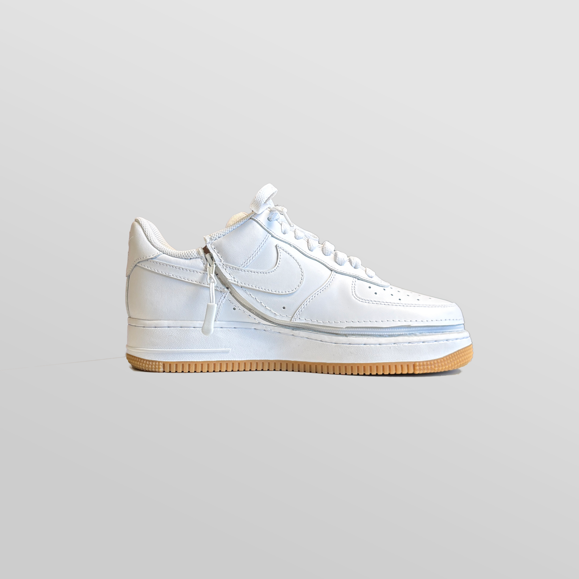A pair of Men's Zipped Nike white shoes with a zipper.