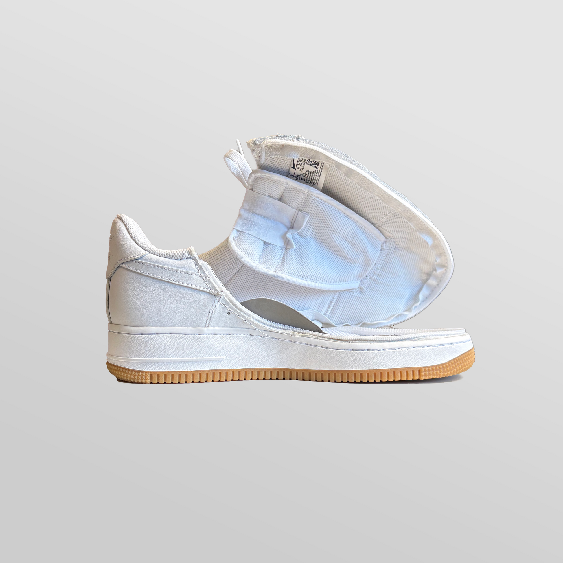 A pair of Men's Zipped Nike white shoes with a zipper.