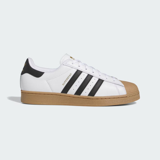 White sneaker with black stripes and brown sole on a light gray background