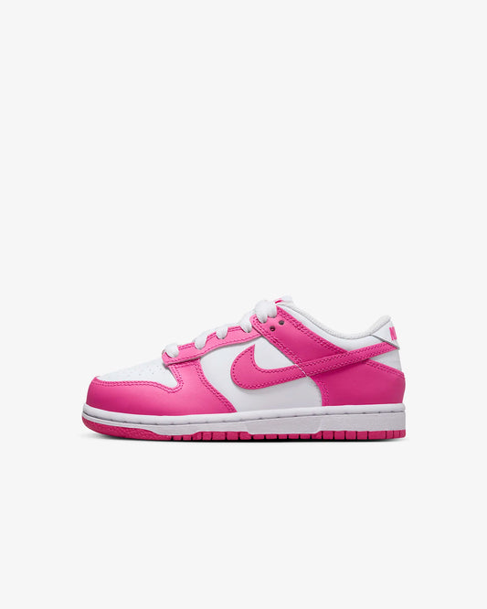 A pair of kids' Nike Dunk Low sneakers in white and pink 