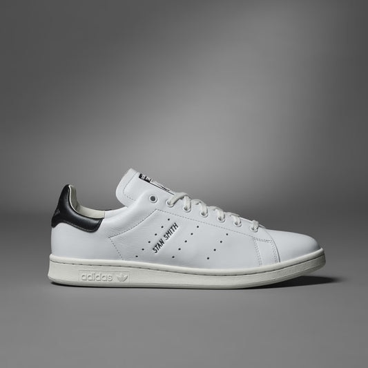White Adidas sneaker with black accents on a gray background